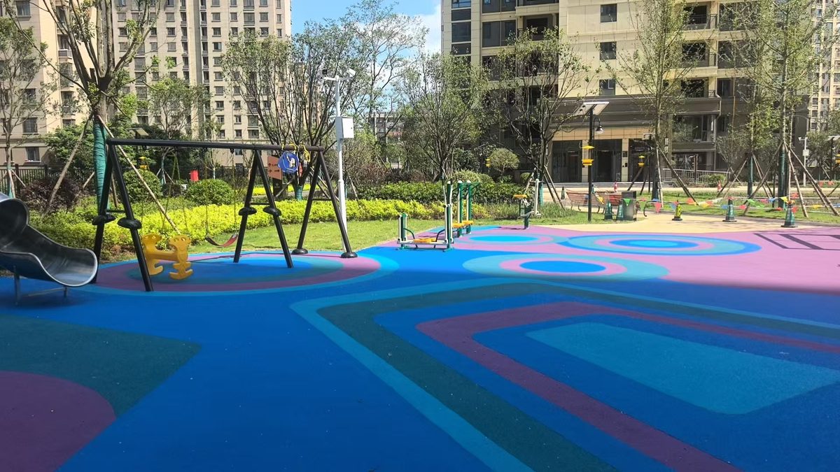 EPDM rubber safety surface in a low age play zone with a rope climbing frame and low slide Superficie de seguridad de caucho EPDM en una zona de juegos para menores con columpio de cuerda y tobogán bajo